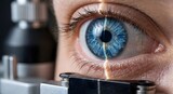 Close up view of human eye undergoing laser eye surgery or medical diagnostic examination with orange scanning beam light passing over blue iris and pupil using professional ophthalmology equipment