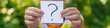 © yanadjan - The child holds a paper with a question mark. Selective focus.