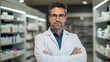© petrrgoskov - Portrait of a handsome pharmacist standing in front of stock in the shop smiling at the camera, close up head and shoulders