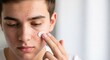 © Eve - Teen boy applying medical acne cream on face skin problems treatment. Young man using spot ointment for pimples and dermatology care. Adolescent skincare and male beauty routine.