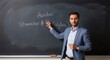 © UnPhouvith - A man in a light blue suit is pointing at a chalkboard with equations written on it. He is a teacher or professor explaining a concept.