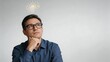© Ethan - Portrait of a pensive businessman wearing glasses looking up at a glowing light bulb icon above his head symbolizing a new idea innovation inspiration creativity and a bright