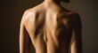 © Jonmart - Close up view of a person s bare back showing shoulder blades and spine structure with dramatic lighting creating shadows and highlights on the skin