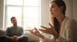 © MARS - Woman talking to a man sitting on a couch in a living room