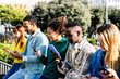 © Xavier Lorenzo - Young group of multiracial people using mobile phone outdoors. Social media and technology lifestyle concept