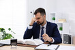 © New Africa - Man feeling fatigue at wooden desk in office
