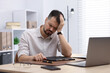 © New Africa - Man feeling fatigue at wooden desk in office