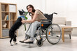 © New Africa - Woman in wheelchair and her service dog indoors