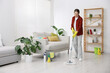 © New Africa - Spring cleaning. Woman tidying up floor with mop at home