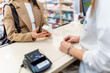 © unai - Customer receiving medication from pharmacist at pharmacy counter