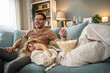 © Migma_Agency - Happy young couple laughing watching movie at home