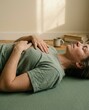 © Breezze - Person lying on yoga mat practicing mindful breathing for mental wellness editorial, resting in peaceful indoor setting with copy space and natural morning light