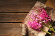 © Pixel-Shot - Beautiful pink hyacinth flowers with envelopes and supplies on brown wooden background