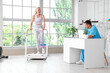 © Pixel-Shot - Male physiotherapist working with mature woman on treadmill in rehabilitation center