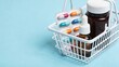© Ekaterina - close-up of miniature shopping basket with medicinal products on smooth pastel blue background. concept of health care, cold and flu season, or pharmaceutical advertising