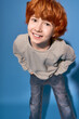 © Bliss - Charming little boy in stylish outfit posing against a vibrant blue backdrop