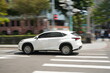 © Image Johnson - White Luxury SUV Driving on Urban City Street