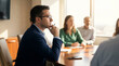 © ViskBx - Thoughtful businessman in glasses contemplating during a corporate meeting in a bright office