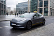 © Maksimoid - Autonomous robotaxi on a modern business district street. Electric urban mobility concept for smart city, ride hailing, and future transport themes