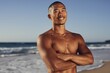 © Iryna - Shirtless man standing with arms crossed on beach shore