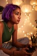 © Iryna - Teen girl focused playing controller in cozy lit room