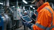 © Vasiliy - Male engineer in high-visibility jacket using a tablet with schematics in a modern factory. Industrial worker monitoring production data on a digital dashboard. Smart manufacturing concept