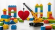 © SashaMagic - Colorful toy crane lifting red heart among building blocks