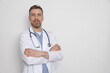 © New Africa - Doctor with stethoscope wearing white coat on light background. Space for text