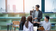 © PAPALAH - A group of Gen Z Asian business consulting, exchanging information in offices, co-working spaces.