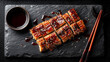 © Lemonkey - Top view of sliced grilled eel fillets glazed with glossy sauce, traditional unagi dish showcasing rich texture and savory Japanese cuisine.
