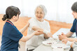 © buritora - Senior women and female occupational therapists at a nursing home are undergoing spoon-using skills training and functional training for eating.