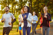 © Studio Romantic - Group of sporty friends people running, jogging outdoors in sunny park, moving together smiling, participating in shared fitness activity, healthy teamwork, joyful energetic, positive group exercise