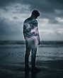 © Eira - Silhouette of a person with a stormy sky overlay on a beach