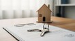 © FahVecStudio - Essential elements for a successful real estate transaction house keys resting on a signed property contract next to a miniature wooden home, symbolizing homeownership and future investments
