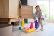 © Pixel-Shot - Cute little girl with bottles of detergent from open drawer in laundry room. Child at risk