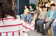 © Studio Romantic - Teenagers students in classroom counseling group discussion. A teacher or psychologist leads a therapy session with teens in a circle. Library shelves. Mental health support idea concept.