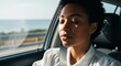 © NE97 - Relaxed woman with closed eyes in a car, peaceful sunlit drive along coast, mental health awareness, mindful travel moment