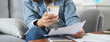 © Pormezz - person pay bills via mobile banking at home