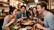 © 현욱 김 - 젊은 친구들이 한국 식당에서 닭갈비를 함께 먹으며 즐거운 대화와 웃음을 나누는 모습.