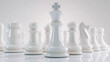 © Tatsiana ST - A close-up of a white chess queen stands in the center of the frame among other white pieces on a glossy surface in a minimalist, light-colored interior.