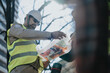 © qunica.com - Two construction engineers examine rolled blueprints during an outdoor site inspection. The engineers review plans together while wearing helmets and high-visibility vests.