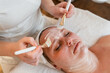 © HNstock - Woman receiving professional facial treatment with mask at spa
