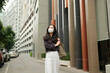 © PaeGAG - Young woman walking city street wearing protective face mask