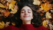 © Solikah - Woman lying in autumn leaves with closed eyes