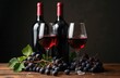 © miss irine - Two bottles of red wine stand behind glasses filled with red wine. Bunches of dark grapes and green vine leaves are on a wooden table. Dark background.