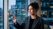 © BENNY - Businesswoman interacting with a holographic digital data interface in a modern office