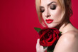 © Volodymyr - Portrait of attractive lovely charming dreamy girl holding red roses, isolated on red studio background.