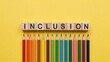 © Volha - Inclusion spelled out with pencils on yellow background