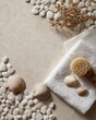 © Esma - White pebbles and seashells with a towel, washcloth, and sponge on a beige background for a spa concept.