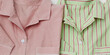 © yrabota - Close up banner with pink green Pajamas folded on white. Top view stylish man and woman sleepwear with natural fabric texture. Cozy striped pyjamas for sleeping, concept of rest, healthy sleep.